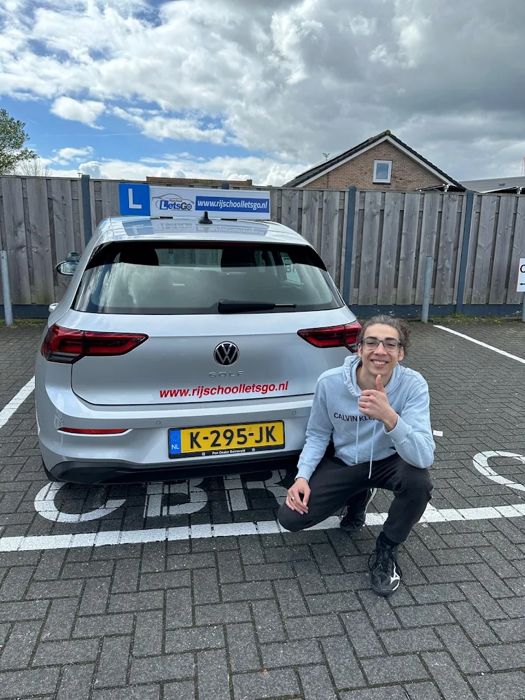 Geslaagde leerling bij de lesauto