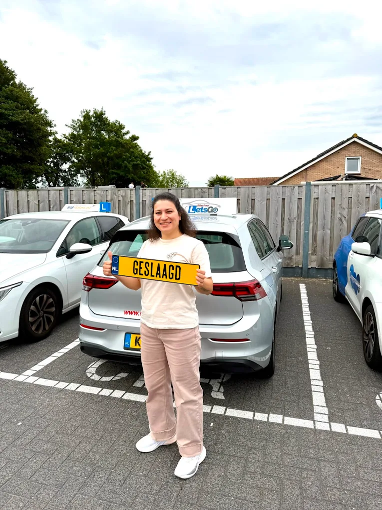 Geslaagde leerling bij de lesauto